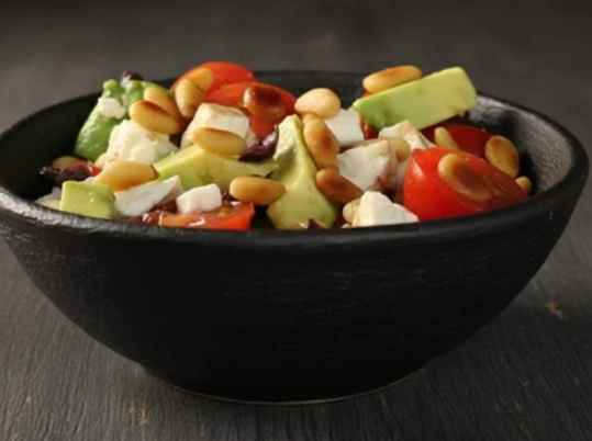 Salade d'avocats avec feta, pignons, tomates et olives noires