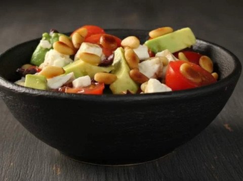 Salade d'avocats avec feta, pignons, tomates et olives noires