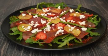 Carpaccio de bresaola, nectarines, fraises et chèvre au miel sur lit de rucola