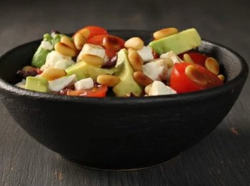 Salade d'avocats avec feta, pignons, tomates et olives noires