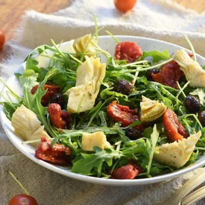 Salade de roquette aux tomates confites et copeaux de parmesan