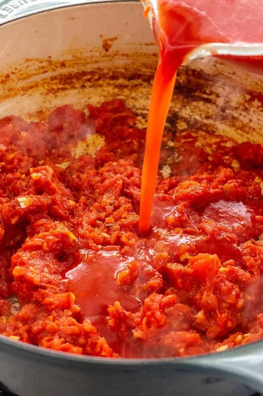 Versement de sauce tomate dans une casserole